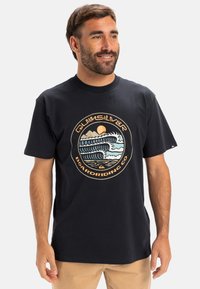 Short-sleeve black cotton t-shirt featuring a circular graphic with waves, mountains, and sun in cream, blue, and orange colors.