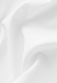 White fabric featuring a smooth, soft texture with subtle folds and ripples, showcasing a plain design without patterns or accents.