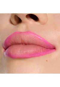 Gros plan sur des lèvres avec des tons rose pâle mat et fuchsia vif. Texture lisse, forme bien définie et teintes de peau naturelles en arrière-plan.