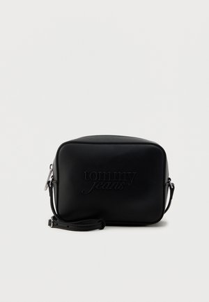 Piccola borsa a tracolla rettangolare nera con il logo "tommy jeans" in rilievo e tracolla regolabile su uno sfondo chiaro e semplice.