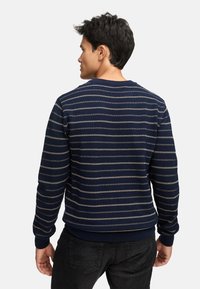 Marineblåstribet sweater med horisontale creme- og lyseblå striber, ribbede manchetter og kant, rund halsudskæring, tekstureret strikket stof.