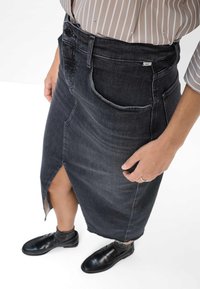 Højtaljet, knælang nederdel i mørk denim med en frontslids, der har baglommer og et lille logo mærke på waistband.