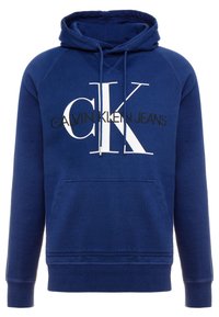 Felpa blu con tasca frontale, cappuccio con cordino e grande logo bianco "CK". Texture morbida e polsini a costine. Realizzata da Calvin Klein Jeans.