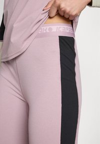Rózsaszín és fekete sport leggings, kontrasztos oldalsó.panellel, puha, nyújtható anyagból készült. Texturált derékrésszel rendelkezik.