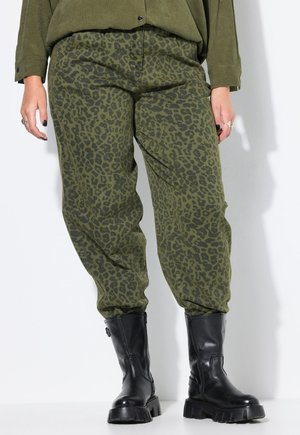 Olijfgroene broek met een zwart luipaardmotief, met een losse pasvorm en een elastische tailleband. Gecombineerd met zwarte chunky enkellaarzen.