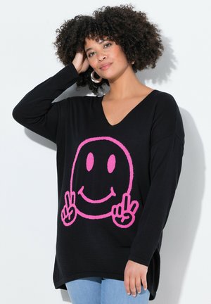 Maglione nero lavorato a maglia con una grande grafica di un sorriso rosa, caratterizzato da un scollo a V e maniche lunghe. Vestibilità casual con orlo arrotondato.