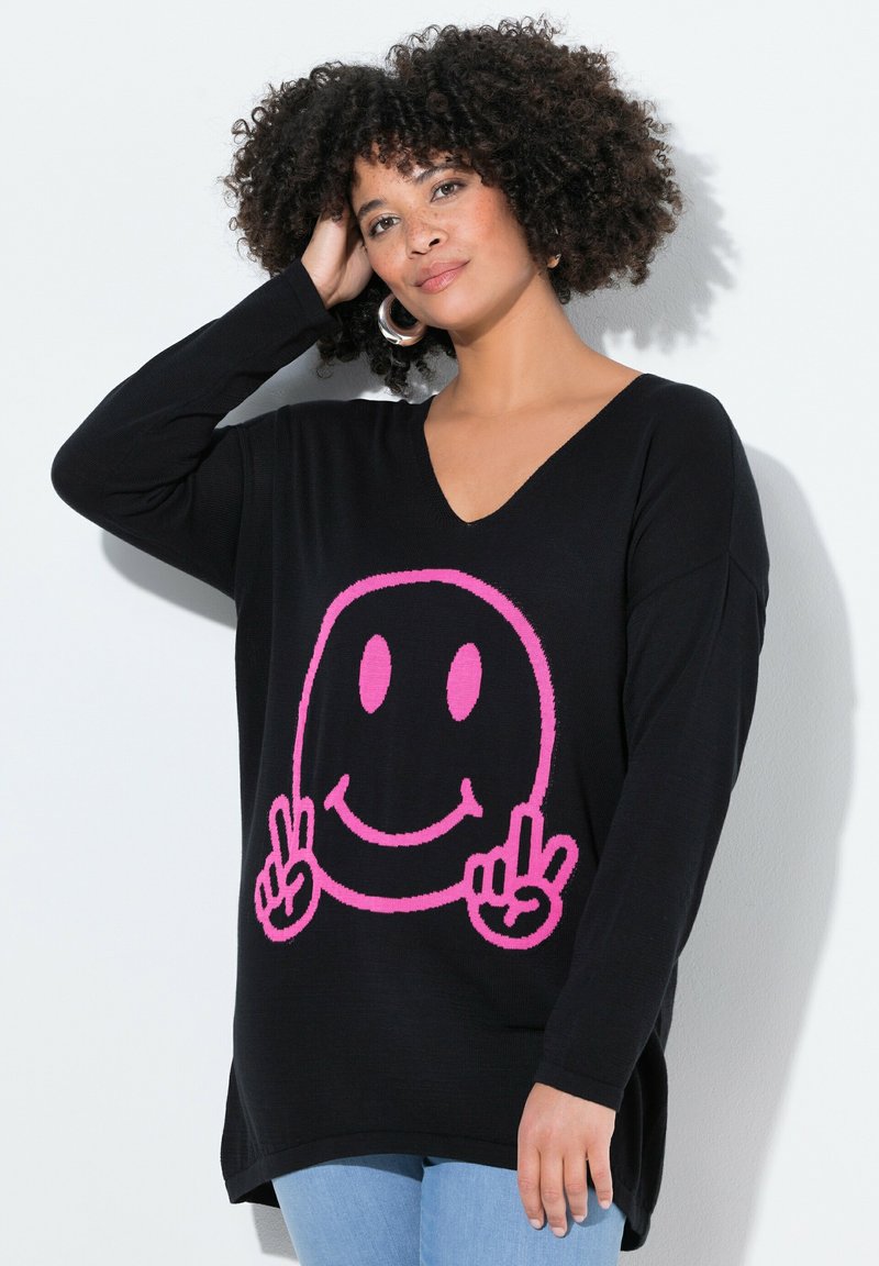 Maglione nero lavorato a maglia con una grande grafica di un sorriso rosa, caratterizzato da un scollo a V e maniche lunghe. Vestibilità casual con orlo arrotondato.