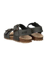 Zwarte sandalen met een kurken voetbed, voorzien van verstelbare riemen en metalen gespen, met een vlakke zool en een gestructureerde bovenkant.