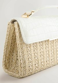 Sac à main en paille tissée avec une base beige texturée et un rabat à motif crocodile blanc brillant. Dispose d'un fermoir et d'une poignée en métal doré.