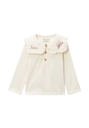 Haut crème à manches longues avec grand col à volants, patte de boutonnage, broderie "love" et cœur avec "dream" sur les bords du col.
