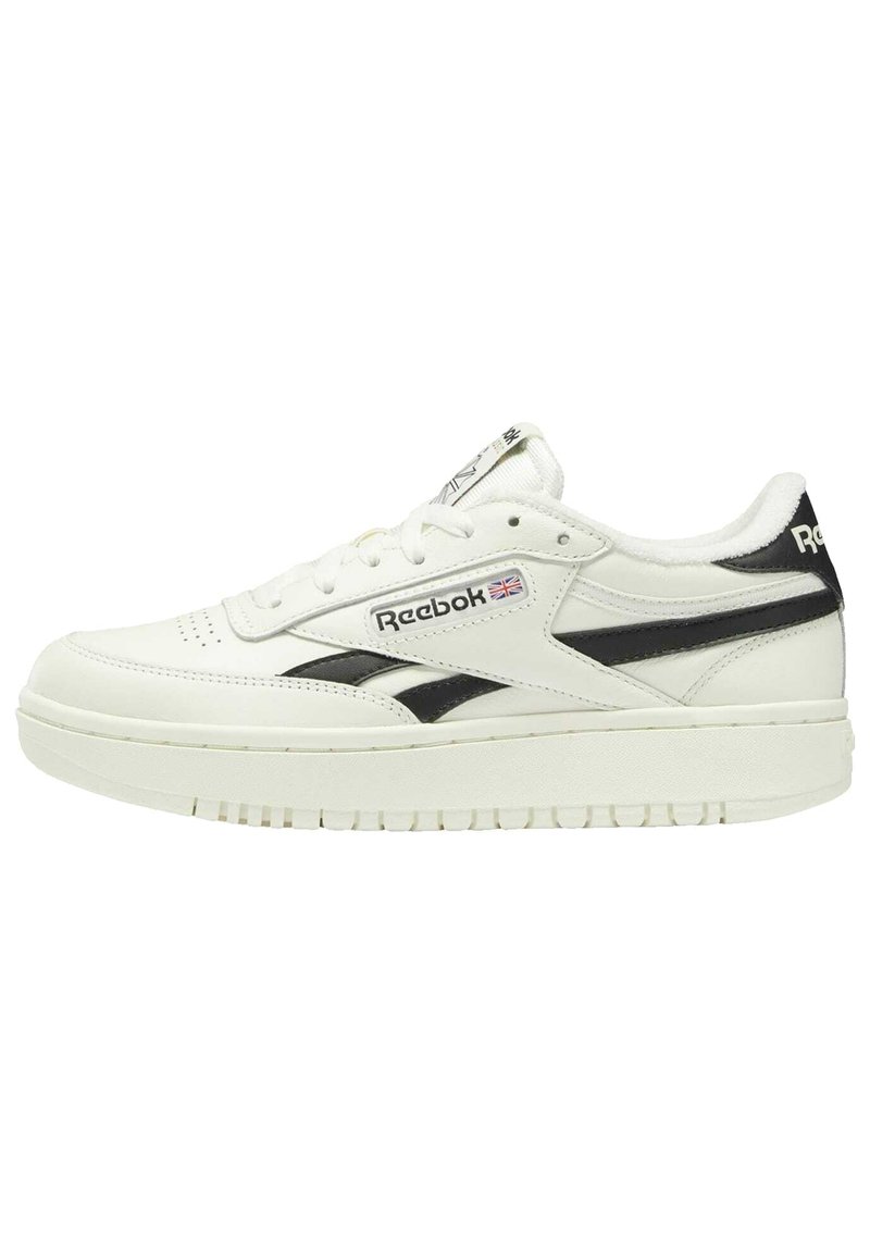 White leather sneaker with black accents, round toe, flat laces, textured sole, and Reebok logo on the side and tongue.
