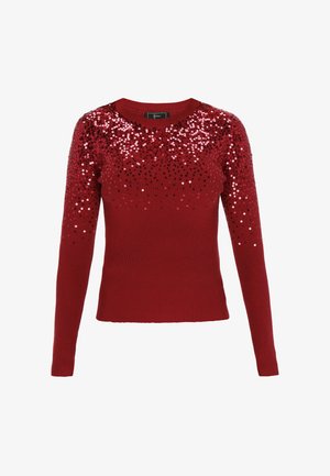 Piros bordázott pulóver, amely flitterekkel díszített nyakkivágással rendelkezik, változó piros és fekete flitterekkel, hosszú ujjakkal és testhezálló fazonnal.