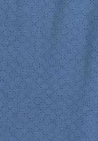 Niebieska tkanina z teksturowanym wzorem małych czarnych kropek ułożonych w diamentowy kształt, podkreślająca miękką, dzianinową fakturę.