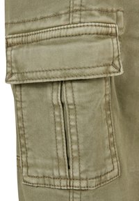Khaki cargo bukser laget av stoff med en stor lommepatch på låret. Har synlige sømmer og en myk, teksturert overflate.