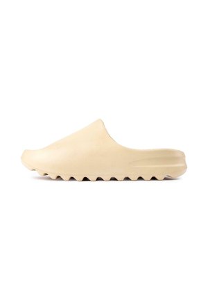 Beige slip-on clog with a smooth finish and a thick, ridged sole. Features a rounded toe and no visible fastenings or embellishments.