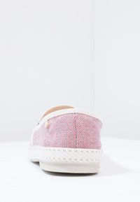 Scarpa slip-on a motivo rosso e bianco con bordi color crema, tessuto testurizzato e suola simile a giuta intrecciata. Presenta un piccolo logo sul lato.
