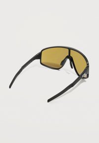 Μαύρα αθλητικά γυαλιά ηλίου με φαρδιούς, περιμετρικούς κίτρινους φακούς και ίσια, υφή μανίκια σε λευκό φόντο.