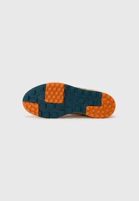 Sola de ténis com um padrão texturizado; materiais de borracha laranja e azul; picos arredondados para tração; design geral de vestuário ativo.
