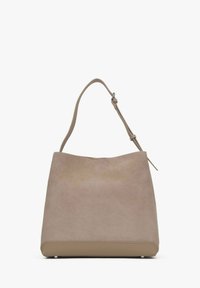 Beżowa torebka z zamszu o gładkim, strukturalnym spodzie i zaokrąglonym wierzchu. Posiada pojedynczy regulowany pasek i minimalistyczny design.