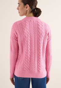 Kabelstrickpullover in leuchtendem Pink mit einem strukturierten Zickzackmuster. Das Design umfasst gerippte Bündchen und einen gerippten Saum für eine optimale Passform.