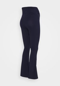 Leggings azul-marinho com corte flare e cintura alta, feitas de tecido elástico suave. Apresentam pregas laterais na cintura para maior conforto.