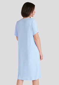 Vestido de manga corta azul claro con un corte relajado, textura suave y longitud a la rodilla. Diseño sencillo sin patrones ni acentos visibles.