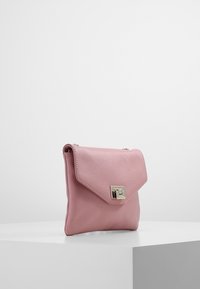 Różowa skórzana torebka z złożonym klapą i złotymi elementami dekoracyjnymi. Gładka faktura i minimalistyczny design, odpowiednia do codziennego użytku.