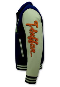 Marineblauwe en crème varsityjack met oranje "Pennfan" borduurwerk op de mouw, ribgebreide manchetten en gestreepte onderkant. Textuurstofcombinatie.