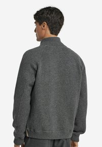 Grauer Fleece-Sweatshirt mit hohem Kragen, Raglanärmeln, geripptem Saum und Bündchen. Weicher Stoff, lässiges Design und minimales Detail.