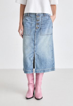 Denim skirt with five buttons down the front, two large pockets, and a center slit. Light blue color with a slightly worn texture.