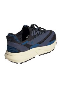 Heren sportschoen met een geprofileerd ontwerp, bestaande uit een combinatie van zwart en marineblauw mesh en leer, en een licht crèmekleurige rubberen zool.