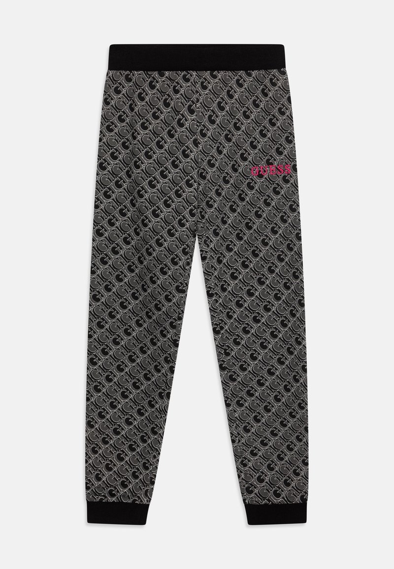 Schwarz-graue Jogginghose mit gemustertem Design mit wiederholtem "G", schwarzem elastischem Bund und Bündchen sowie pinkem "GUESS"-Logo am rechten Oberschenkel.