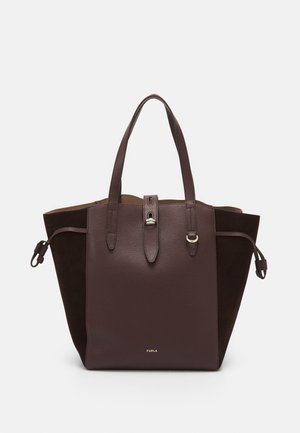 Ciemnobrązowa skórzana torba typu tote z dwoma uchwytami, przednim paskiem z złotą klamrą, bocznymi ściągaczami oraz napisem marki "FURLA" na dole pośrodku.