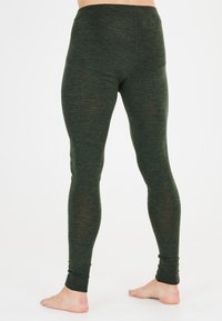 Gröna leggings gjorda av ett texturerat, elastiskt tyg. Har en hög midja och en åtsittande passform som smalnar av vid anklarna.