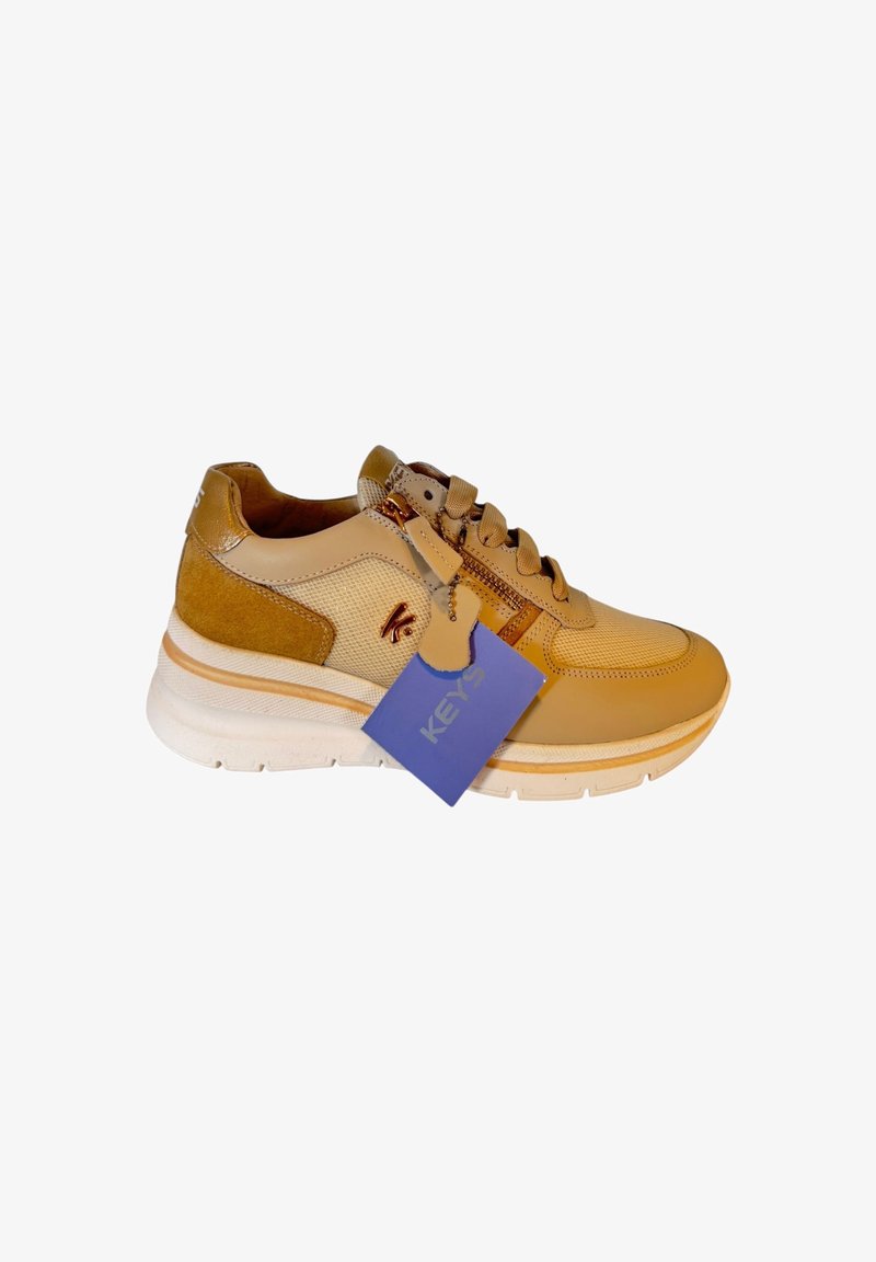 Sneaker beige chiaro con accenti in rete e suede, suola crema, punta rotonda e cuciture dettagliate; etichetta blu attaccata.