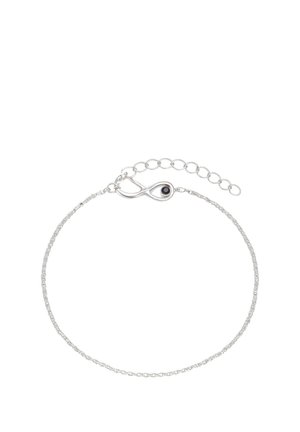 Delicato braccialetto a catena in argento con ciondolo a simbolo dell'infinito, caratterizzato da un piccolo dettaglio occhio nero e una chiusura regolabile a maglie.
