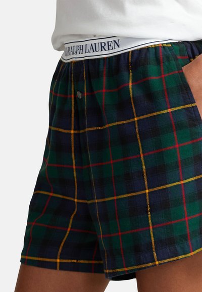 Kostkované šortky v tmavě zelené, námořnické modré a žluté barvě. Mají zapínání na knoflík a bílý pas s nápisem "RALPH LAUREN" modrými písmeny.