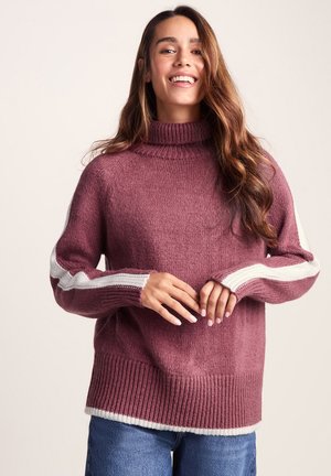 Purple knit sweater with a turtleneck, ribbed hem, and long sleeves featuring white diagonal stripes along the arms. Smooth texture.