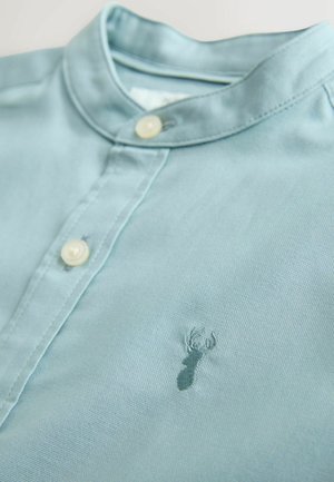 Jasnoniebieska koszula z kołnierzykiem wykonana z miękkiej tkaniny, z zapięciem na guziki i małym haftowanym logo homara na piersi.