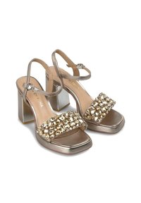 Metallisch gouden open teen hoge hakken sandalen met een dikke blokhak, met eenbejeweled band over de voorkant en een enkelband met gesp.