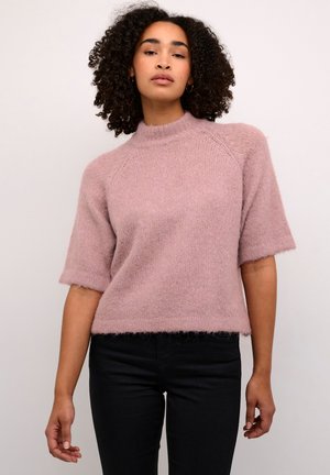 Roze, kortemouw gebreid truitje met een hoge hals. Zachte textuur, relaxte pasvorm en ribgebreide boorden. Gepaard met een zwarte denim broek.