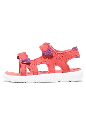 Sandalia infantil de color rosa coral con correas moradas de cierre de gancho y lazo y suela blanca texturizada, diseño abierto con paneles laterales perforados.