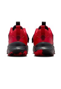 Punaiset urheilukengät, joissa on teksturoitu pinta, mustat yksityiskohdat, säädettävät remmit ja kuvioitu ulkopohja, jossa on punainen ja musta kuvio.