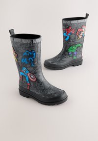 Svarta gummistövlar med Marvel-superhjältegrafik i rött, blått, grönt och gult. Texturerad yta med robust sula och dragflikar.