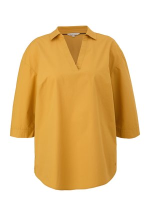 Blusa larga giallo senape con maniche tre quarti, colletto e apertura a V, mostrata su sfondo bianco.