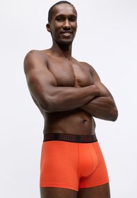 Puma muške bokserice u jarko narančastom pamuku s crnim pojasom s logom, s prilagođenim krojem i glatkom teksturom.