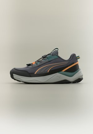 Sneaker gris foncé et bleu sarcelle avec des touches orange, semelle blanche épaisse et fermeture à lacets, présenté de profil sur un fond uni.