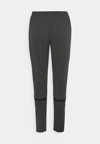 Pantalon de sport gris foncé fuselé avec taille élastique et bandes horizontales noires au-dessus des genoux sur fond blanc.