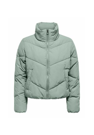 Lichtgroene, kortere pufferjack met hoge kraag. Heeft een ritssluiting aan de voorkant, een chevron-quiltingpatroon en lange, iets opgeblazen mouwen.