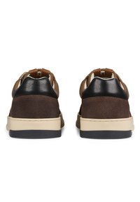 Scarpe marroni con tomaia in rete, accenti in pelle nera e suola color crema. Presentano una forma arrotondata con dettagli testurizzati sul retro.